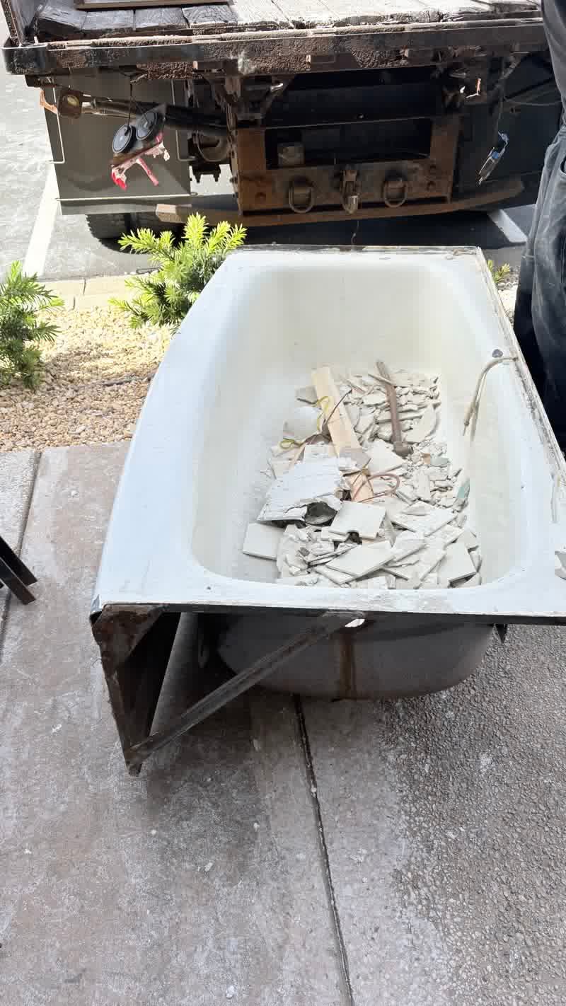 Bathtub filled with tile demolition debris